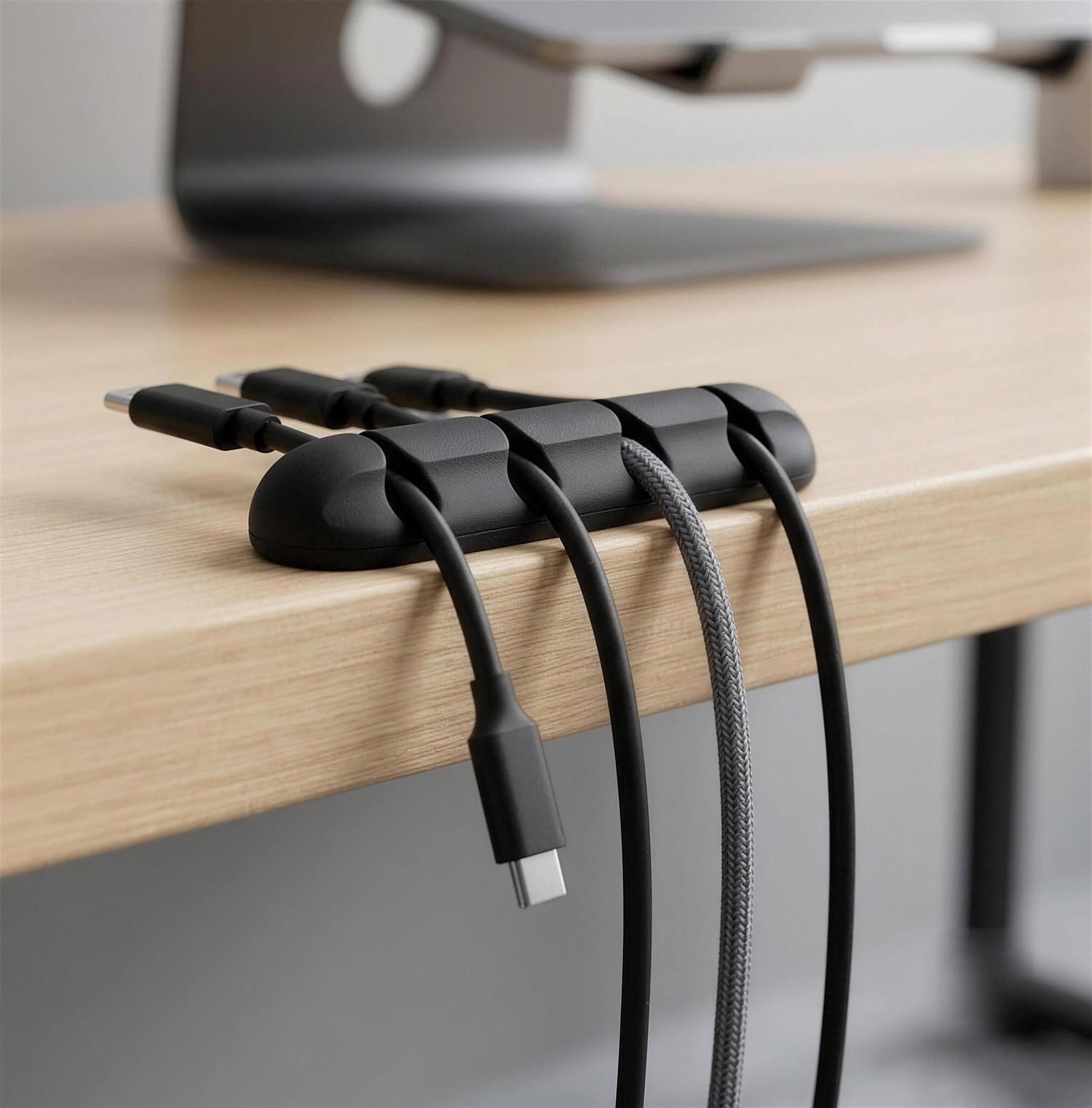 Organizador de cables ERGORA sujetando cables en el borde de un escritorio